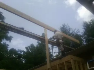 Carpenter setting a ridge beam over a new addition frame — Ice Dam Removal by Roofing Brothers in Crawfordsville