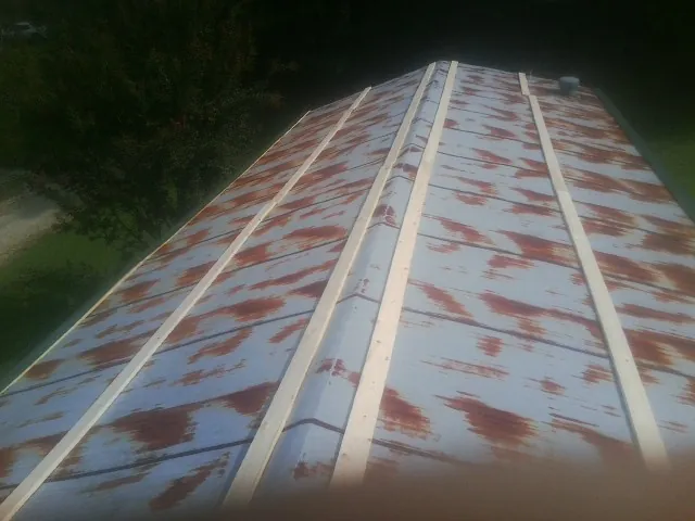 Rusted metal roof panels with new wood purlins before replacement — Storm Damage Roof Repair in Crawfordsville by Roofing Brothers
